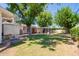 Large, grassy backyard with a covered patio and mature trees providing shade at 4238 E Mitchell Dr, Phoenix, AZ 85018