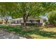 Lush front yard with mature trees shading a charming home with a pergola-covered entrance at 4238 E Mitchell Dr, Phoenix, AZ 85018