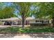 Charming home with a well-manicured lawn, mature tree, and inviting red front door at 4238 E Mitchell Dr, Phoenix, AZ 85018