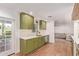 Bright kitchen with green cabinets, stainless steel appliances, quartz countertops, and wood floors at 4238 E Mitchell Dr, Phoenix, AZ 85018