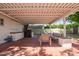 Covered patio features brick flooring, comfortable seating and outdoor kitchen with a built-in grill at 4238 E Mitchell Dr, Phoenix, AZ 85018