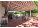 This covered brick patio offers an outdoor living space with a grill and seating at 4238 E Mitchell Dr, Phoenix, AZ 85018