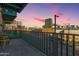 Balcony view showcases urban landscape with outdoor seating, metal railings, and buildings against a vivid sky at 424 S 2Nd St # 203, Phoenix, AZ 85004