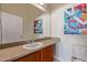 Well-lit bathroom featuring colorful artwork, enhancing the aesthetic appeal and personal touch of the space at 424 S 2Nd St # 203, Phoenix, AZ 85004