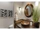 Elegant powder room features copper sink, stylish mirror and decor, and tasteful wall art at 4327 E Capricorn Pl, Chandler, AZ 85249