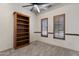 Cozy bedroom featuring neutral walls, carpet, ceiling fan, and a built-in wooden bookshelf at 4327 E Capricorn Pl, Chandler, AZ 85249
