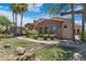 Inviting single-story home with stone accents, a tile roof, manicured lawn, and mature desert landscaping at 4327 E Capricorn Pl, Chandler, AZ 85249