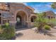 Charming single-story home featuring a gated entrance, stone archway, tile roof, and desert landscaping at 4327 E Capricorn Pl, Chandler, AZ 85249