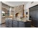 Gourmet kitchen features a large island, stone accent wall, and modern appliances at 4327 E Capricorn Pl, Chandler, AZ 85249
