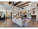 Open living room with beamed ceiling, ceiling fans, fireplace, and stone tile flooring at 4327 E Capricorn Pl, Chandler, AZ 85249