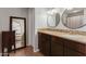 This bathroom features double sinks with granite counters and wood cabinets at 4419 W Vogel Ave, Glendale, AZ 85302