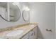 Bright bathroom featuring double sinks with granite counters and modern round mirrors at 4419 W Vogel Ave, Glendale, AZ 85302