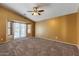 Spacious bedroom featuring plush carpeting, a ceiling fan, and a bay window at 45131 W Horse Mesa Rd, Maricopa, AZ 85139