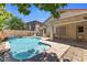 A backyard pool features a unique design with a small waterfall feature and a beautiful, sunny patio area at 45131 W Horse Mesa Rd, Maricopa, AZ 85139