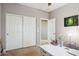 Bedroom features a large closet, beige carpet, white walls, and a desk with a lamp at 46141 W Rainbow Dr, Maricopa, AZ 85139