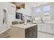Kitchen island offers seating, sleek countertops and modern cabinets at 46141 W Rainbow Dr, Maricopa, AZ 85139