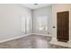 Inviting living room with wood floors, large windows, and neutral paint, providing a versatile space at 46141 W Rainbow Dr, Maricopa, AZ 85139