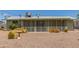 A close-up shot of the backyard featuring desert landscaping and a screen enclosed back patio at 5309 E Butte St, Mesa, AZ 85205