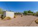 Home backyard showing desert landscaping, a screen enclosed patio, and storage shed at 5309 E Butte St, Mesa, AZ 85205