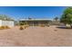 View of the home's backyard with desert landscaping, a screen enclosed patio, and a small storage shed at 5309 E Butte St, Mesa, AZ 85205