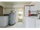 Laundry room includes washer, dryer, water heater, and utility sink at 5309 E Butte St, Mesa, AZ 85205