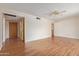 Open living room with wood floors, a ceiling fan, and multiple doorways for easy access at 5309 E Butte St, Mesa, AZ 85205