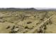 This is an aerial view of a home on a large desert lot, including a small outbuilding and a distant mountain view at 53925 W Stallion Rd, Maricopa, AZ 85139