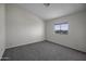 Bright bedroom featuring neutral decor, carpet flooring, and a window view at 53925 W Stallion Rd, Maricopa, AZ 85139