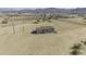 This shows the exterior of a small home on a large, sandy lot, against a backdrop of distant mountains at 53925 W Stallion Rd, Maricopa, AZ 85139
