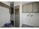 This laundry room features overhead cabinets, utility connections, and durable flooring at 53925 W Stallion Rd, Maricopa, AZ 85139
