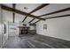 Living room with exposed beams, stone fireplace, wood-look flooring, and natural light at 53925 W Stallion Rd, Maricopa, AZ 85139