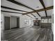 Living room with exposed beams, stone fireplace, wood-look flooring, and natural light at 53925 W Stallion Rd, Maricopa, AZ 85139
