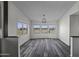 Bright living room with large windows showcasing desert views and wood-look flooring at 53925 W Stallion Rd, Maricopa, AZ 85139