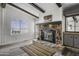 Cozy living room with a striking stone fireplace, wood beams, and natural light from the windows at 53925 W Stallion Rd, Maricopa, AZ 85139