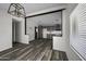 Bright living room with gray wood floors, an open layout, and stylish lighting at 53925 W Stallion Rd, Maricopa, AZ 85139