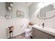 Stylish powder room with a decorative mirror, a gray vanity, and white wainscoting walls at 6712 W Miner Trl, Peoria, AZ 85383