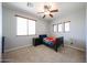 Bright bedroom featuring a ceiling fan, a cozy bed with a vibrant blanket, and carpeted floors at 6712 W Miner Trl, Peoria, AZ 85383