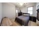 Functional bedroom featuring two dressers, a bed with cozy gray linens, and neutral carpet at 6712 W Miner Trl, Peoria, AZ 85383