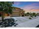 Two-story home featuring a stone column entryway, three car garage, desert landscaping, and a wide driveway at 6712 W Miner Trl, Peoria, AZ 85383