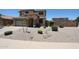 Well-maintained front yard featuring desert landscaping, small bushes and trees, with a two-car garage at 6712 W Miner Trl, Peoria, AZ 85383