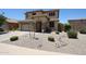 Well-maintained front yard featuring desert landscaping, small bushes and trees, with a two-car garage at 6712 W Miner Trl, Peoria, AZ 85383