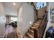 Hallway with staircase, hardwood floors, and access to the living room with a comfortable leather couch at 6712 W Miner Trl, Peoria, AZ 85383
