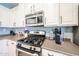 This kitchen showcases stainless steel appliances, including a gas range, microwave, and light countertops at 6712 W Miner Trl, Peoria, AZ 85383