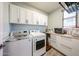 A well-equipped laundry room with side-by-side washer and dryer and ample storage space at 6712 W Miner Trl, Peoria, AZ 85383