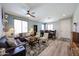 Bright living room featuring hardwood floors, a gray sofa, dining table, and lots of natural light at 6712 W Miner Trl, Peoria, AZ 85383