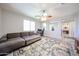 Open layout living room has an area rug, a sectional sofa, and natural light from windows at 6712 W Miner Trl, Peoria, AZ 85383