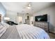 Comfortable main bedroom featuring a ceiling fan, a large television, and an adjacent bathroom at 6712 W Miner Trl, Peoria, AZ 85383