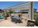 Inviting outdoor dining area featuring a built-in grill, fireplace, and a pergola for shade at 6712 W Miner Trl, Peoria, AZ 85383