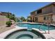Beautiful backyard pool and spa with a waterfall feature and comfortable lounge seating area at 6712 W Miner Trl, Peoria, AZ 85383