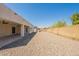 Expansive backyard featuring a covered patio, neutral gravel, and perimeter block wall fencing at 6719 S Hardy Dr, Tempe, AZ 85283